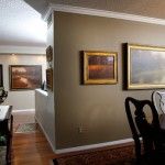 A trio of Brent Cotton landscapes in the dining room of Bullard’s Denver condominium, with the “million-dollar wall” in the background.